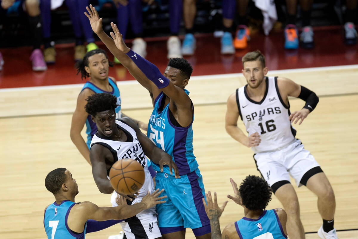 San Antonio Spurs guard/forward Sidy Cissoko (25) passes while surrounded by Charlotte Hornets ...