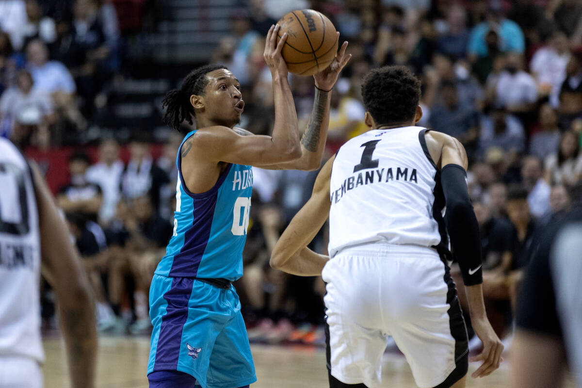 Charlotte Hornets guard Nick Smith Jr. (00) looks to pass while San Antonio Spurs forward Victo ...