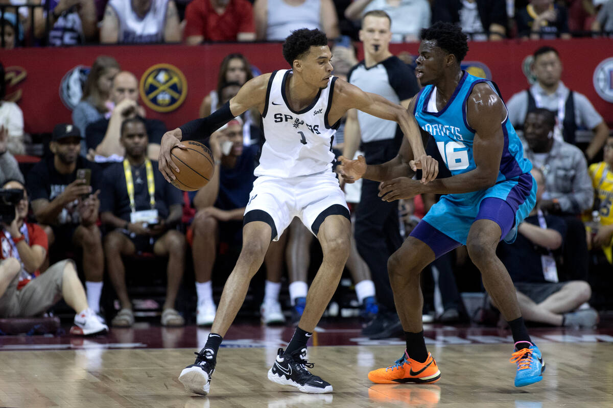 San Antonio Spurs forward Victor Wembanyama (1) dribbles while guarded by Charlotte Hornets for ...