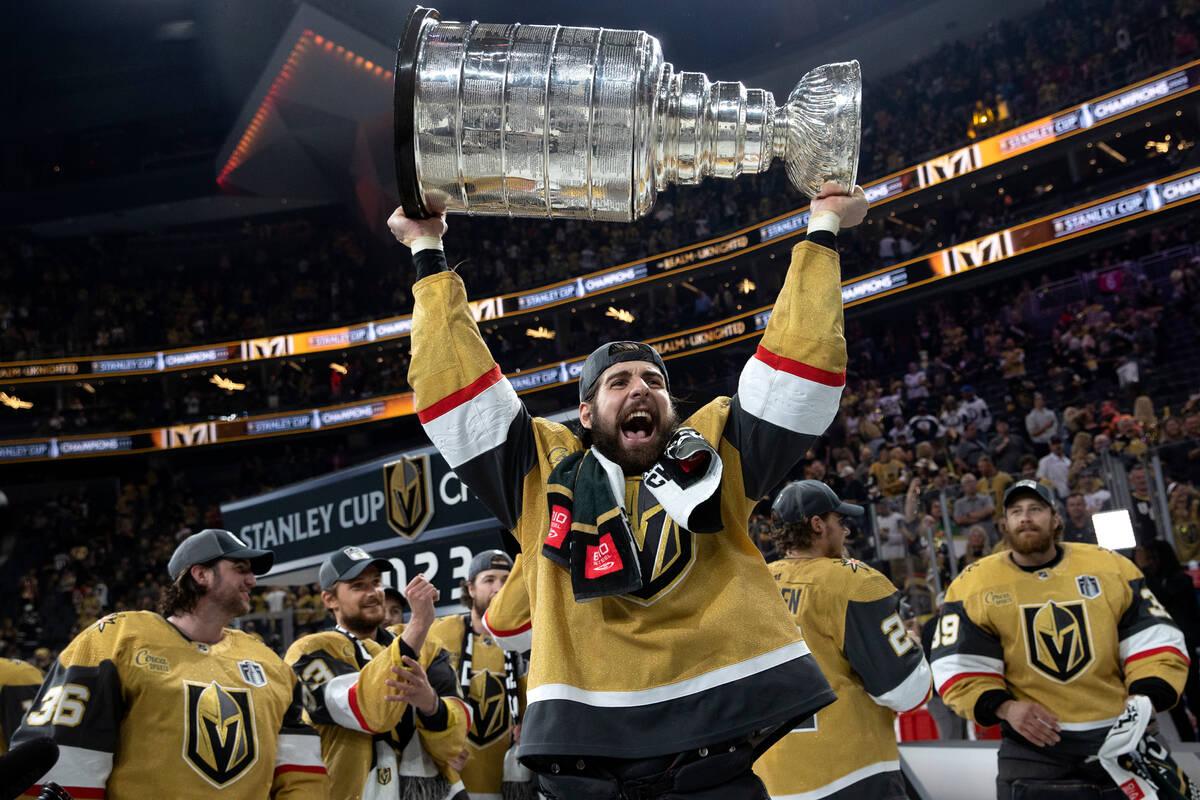 Golden Knights defenseman Nic Hague cheers while holding up the Stanley Cup after defeating the ...