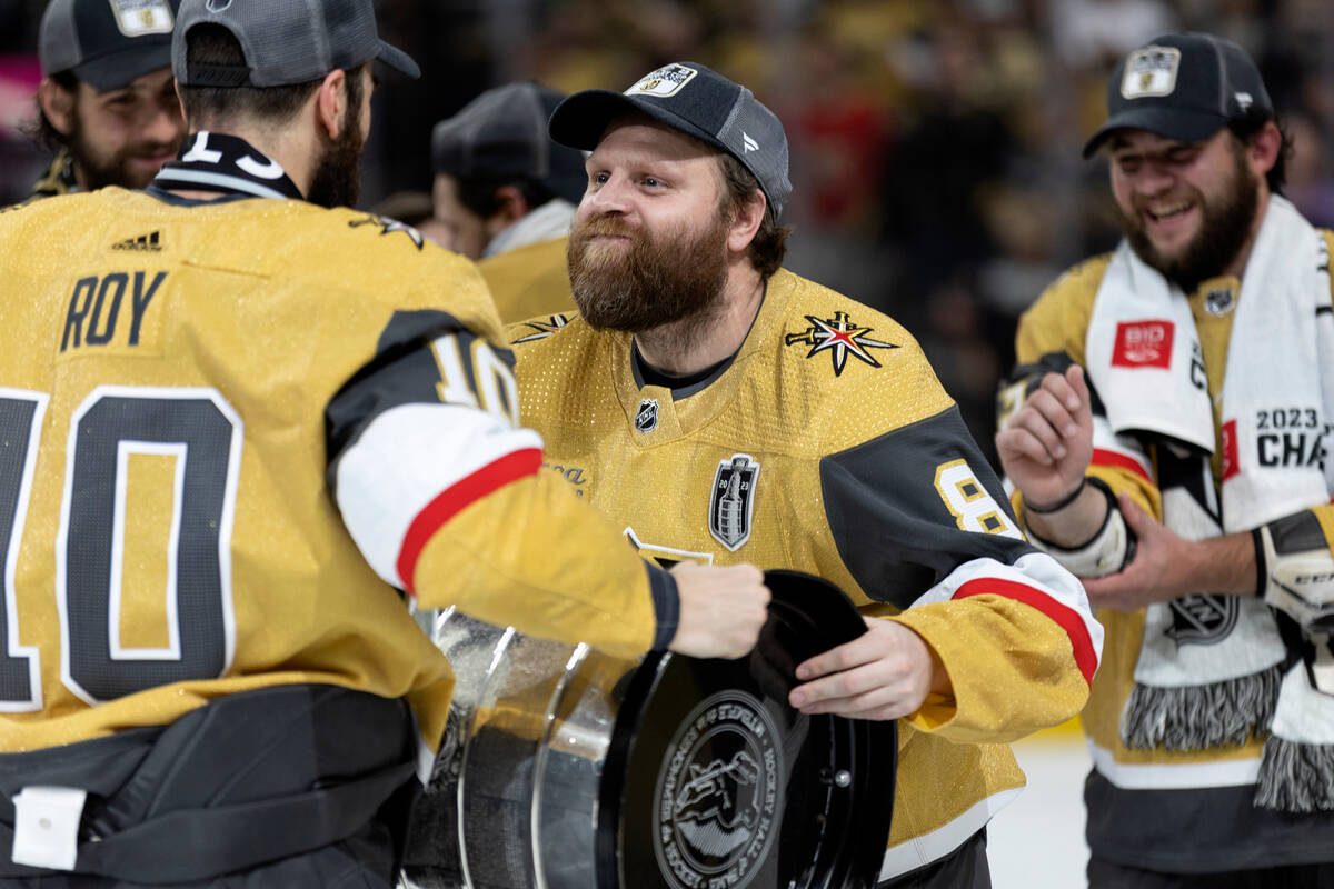 Golden Knights right wing Phil Kessel (8) receives the Stanley Cup from center Nicolas Roy (10) ...