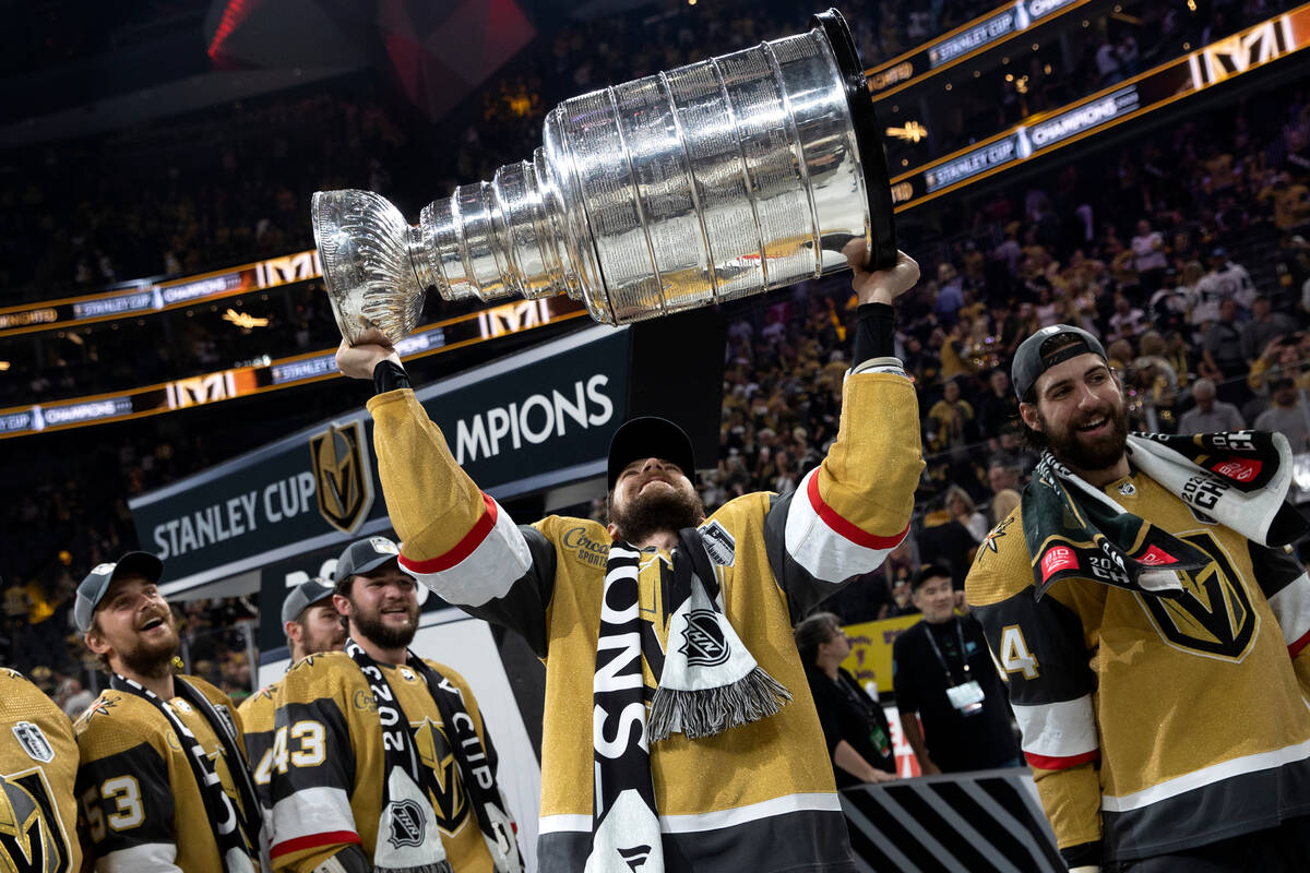 Golden Knights defenseman Shea Theodore (27) celebrates with the Stanley Cup after winning the ...