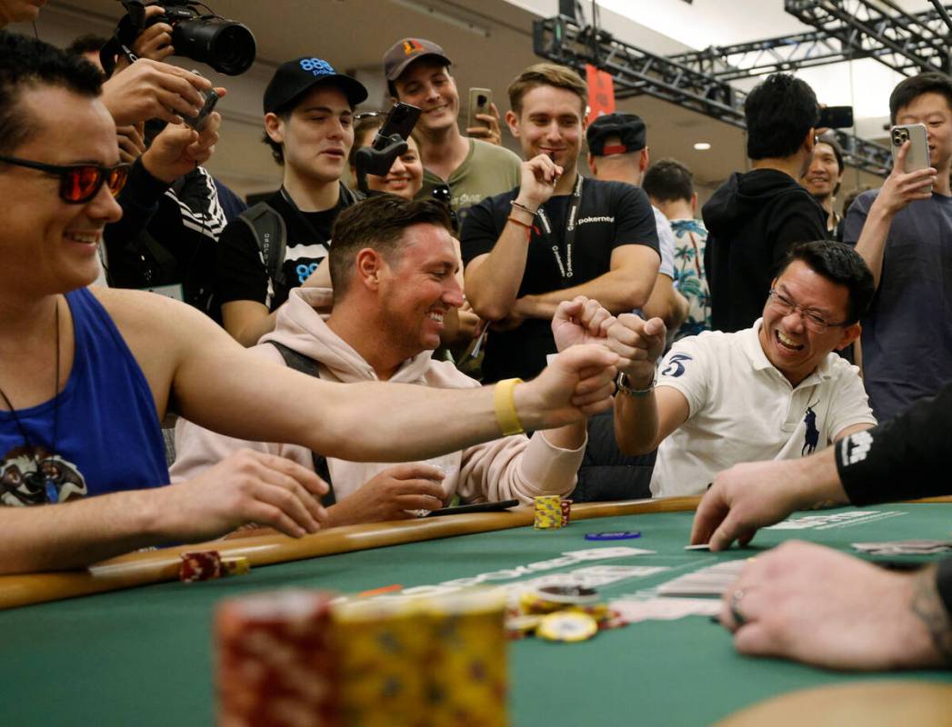 Thanh Nguyen, right, is congratulated by other players after he was not eliminated during World ...