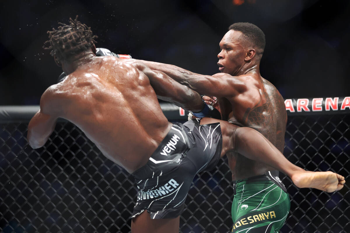 Israel Adesanya, right, throws a punch against Jared Cannonier during the fourth round of a mid ...