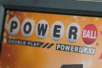FILE - A display panel advertises tickets for a Powerball drawing at a convenience store, Nov. ...