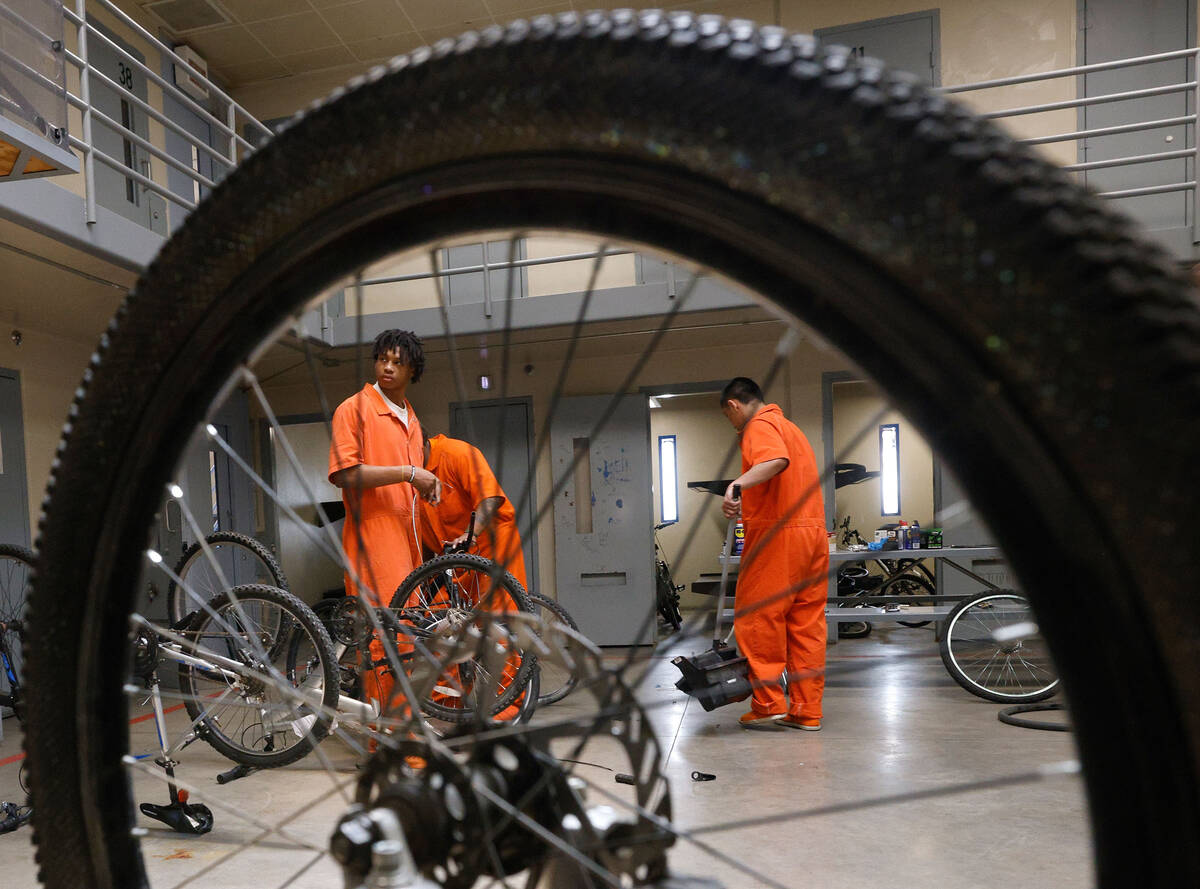 Inmate Erick Wilson, left, repairs a bike with other inmates at North Las Vegas Community Corre ...