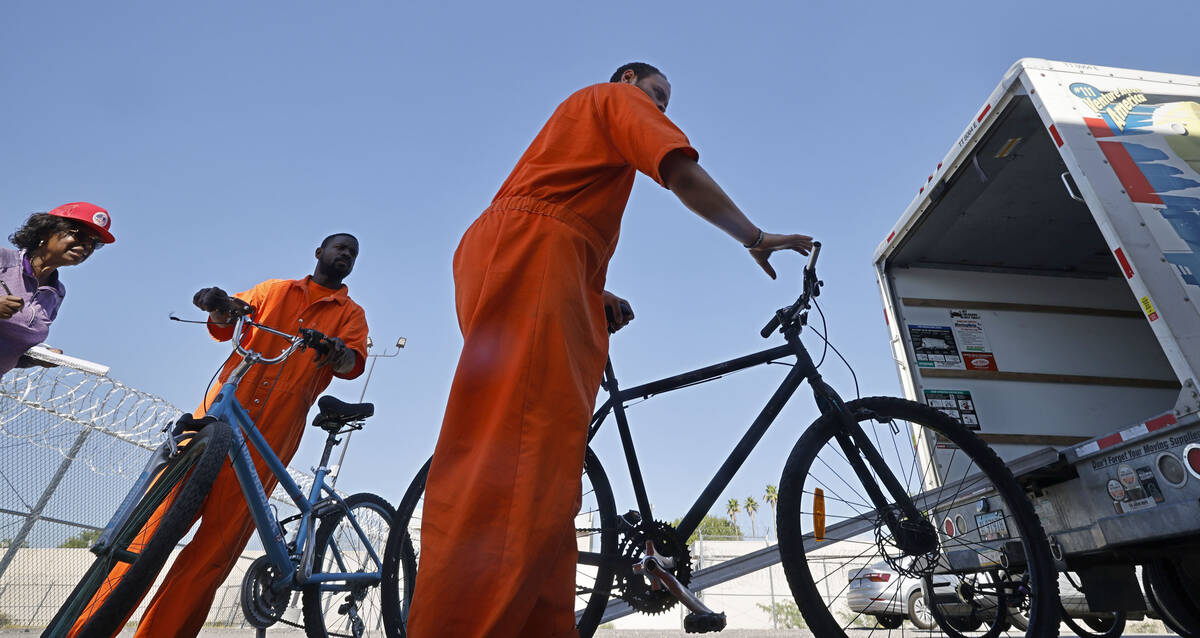 Inmates Omar Kemp, center, and Jacquar Sprinkle, right, unload bikes from a truck at North Las ...