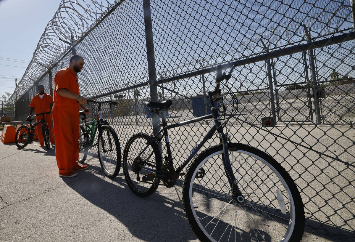 Inmates Jacquar Sprinkle, foreground, and Ryan Brandon take bikes to load onto a truck for Nati ...