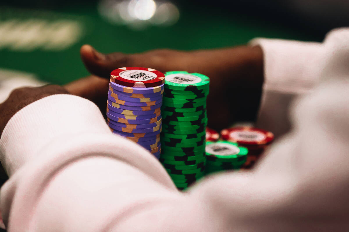 Maurice Hawkins surrounds his poker chips with his hands during the World Series of Poker $10,0 ...