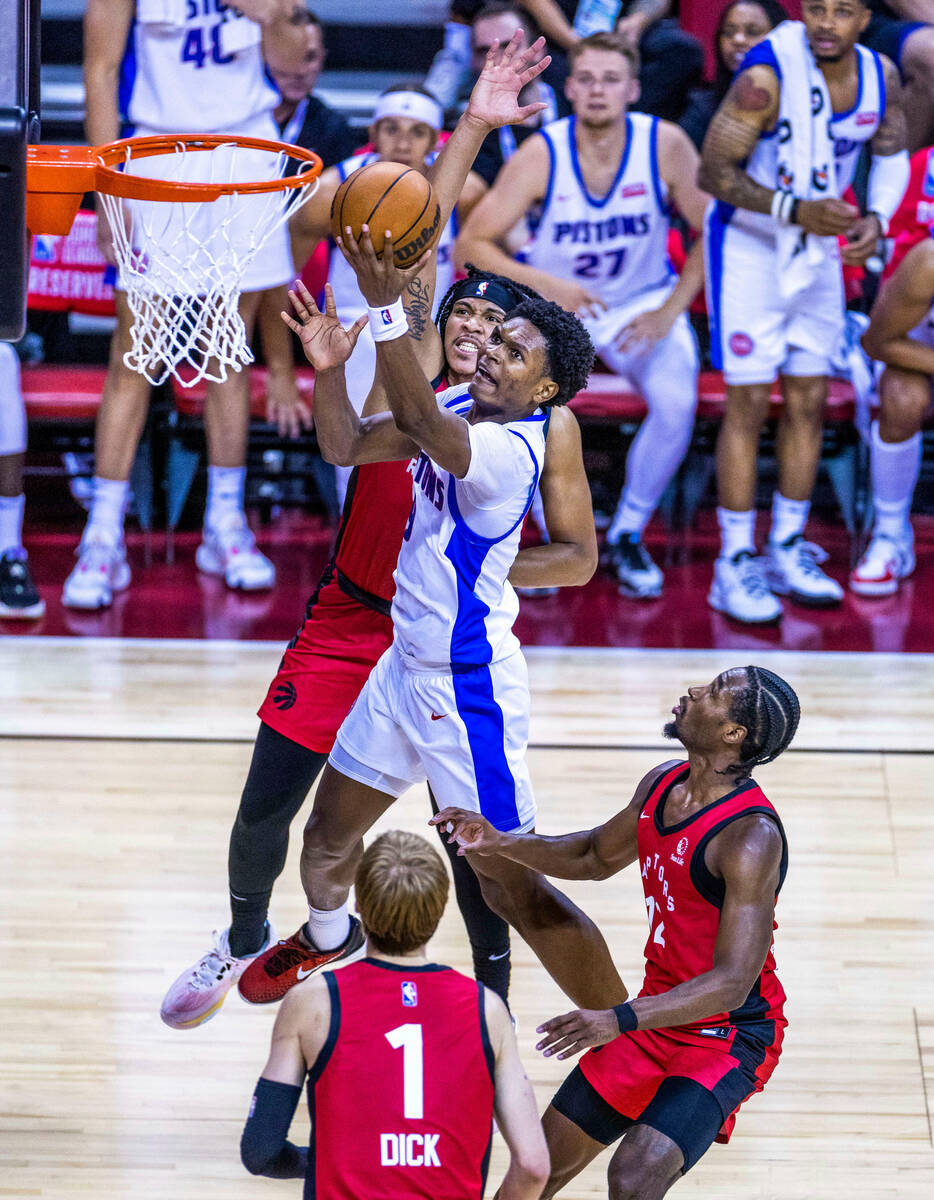 Detroit Pistons guard Jared Rhoden (8) elevates for a basket past Toronto Raptors guard Ron Har ...
