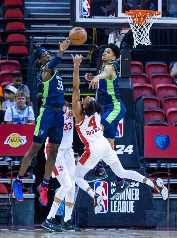 The Timberwolves forward Leonard Miller (33) rejects a shot attempt by the Hawks guard Kobe Buf ...