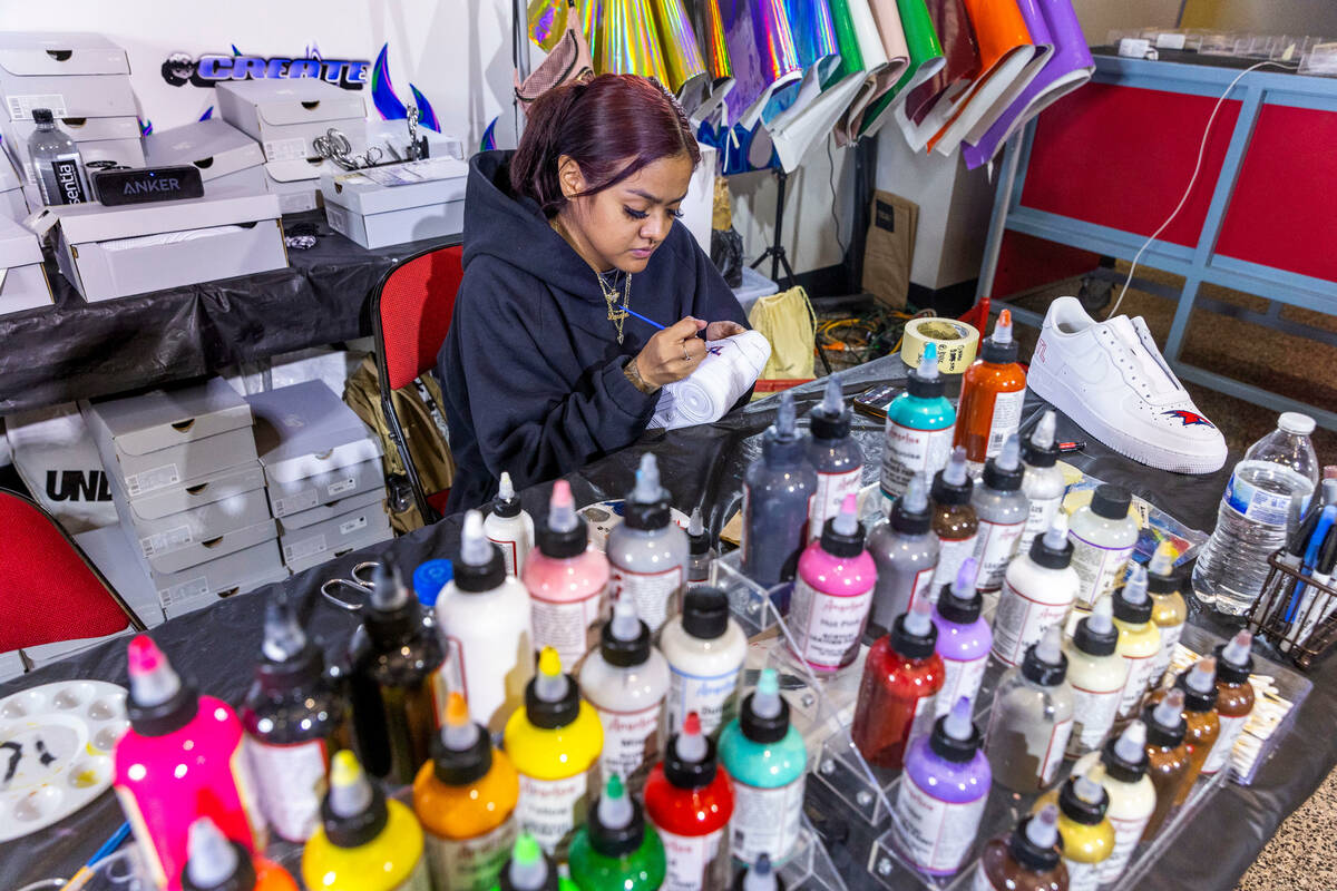 Myah Alvarado paints a custom sneaker in the Majorwavez Lab booth on the concourse during NBA S ...