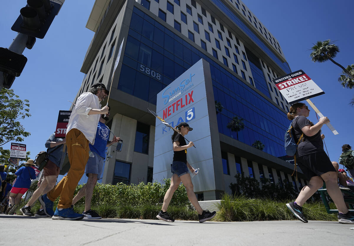 Picketers carry signs outside Netflix during a Writers Guild rally on Thursday, July 13, 2023, ...