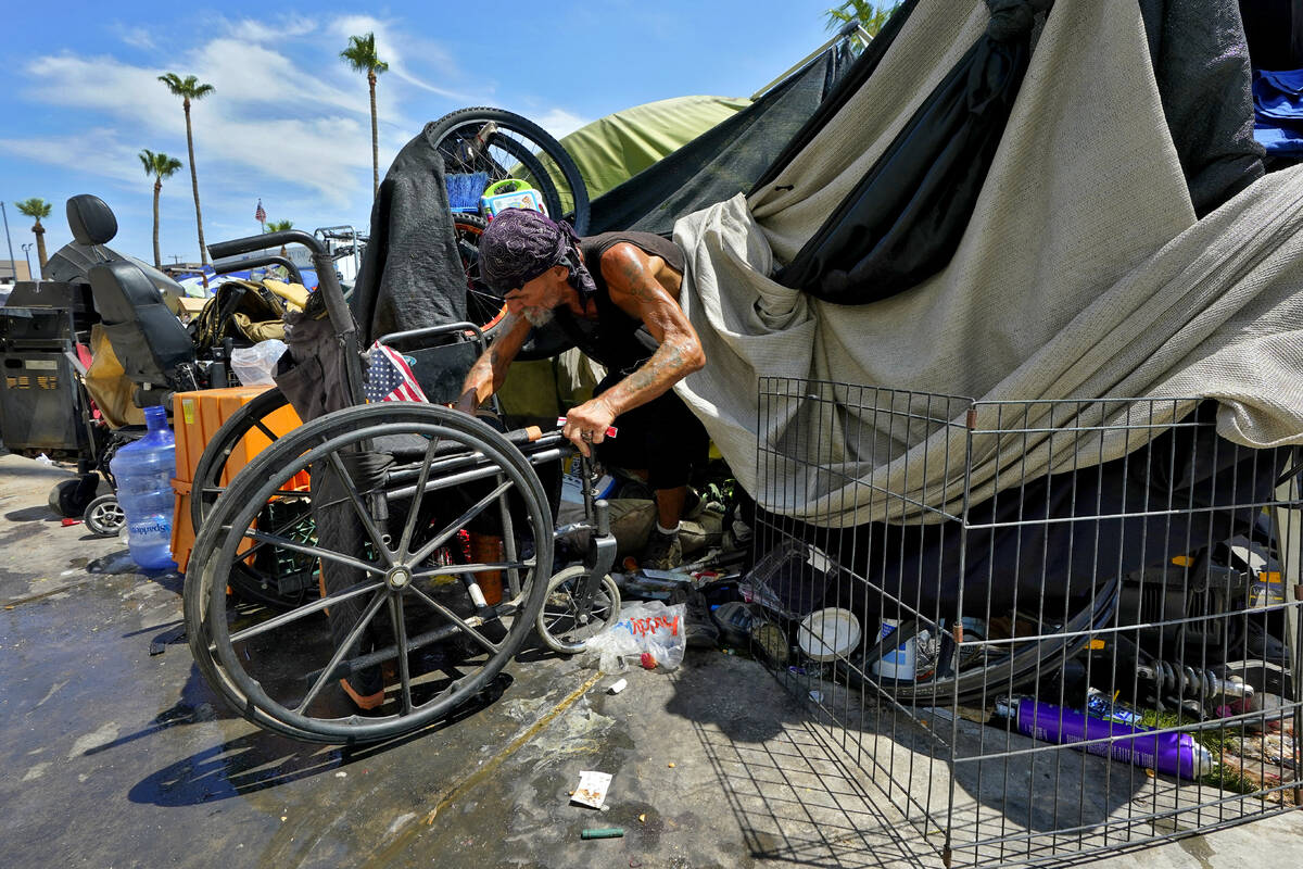 Charles Sanders, 59, climbs out of his tent inside the homeless encampment called "The Zon ...