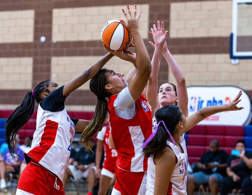 Nation Williams (44), center, is fouled on a shot by Qandace Samuels (20) during a Jr.NBA show ...