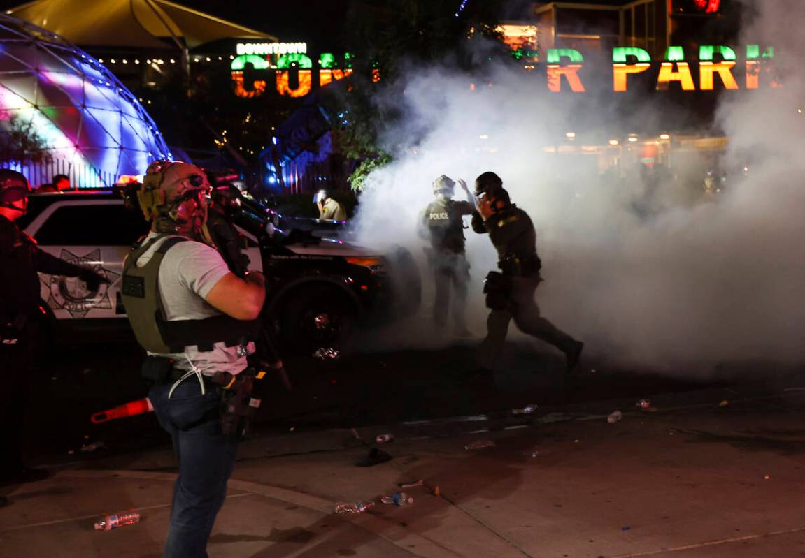 A man who appears to be impersonating a federal agent, left, stands among Las Vegas police offi ...