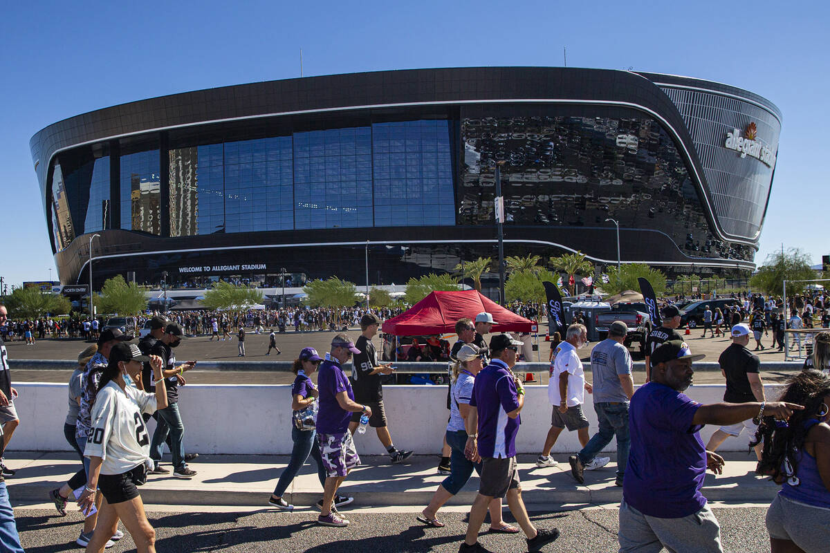 Football fans walk along the Hacienda Bridge before the game between the Raiders and the Baltim ...