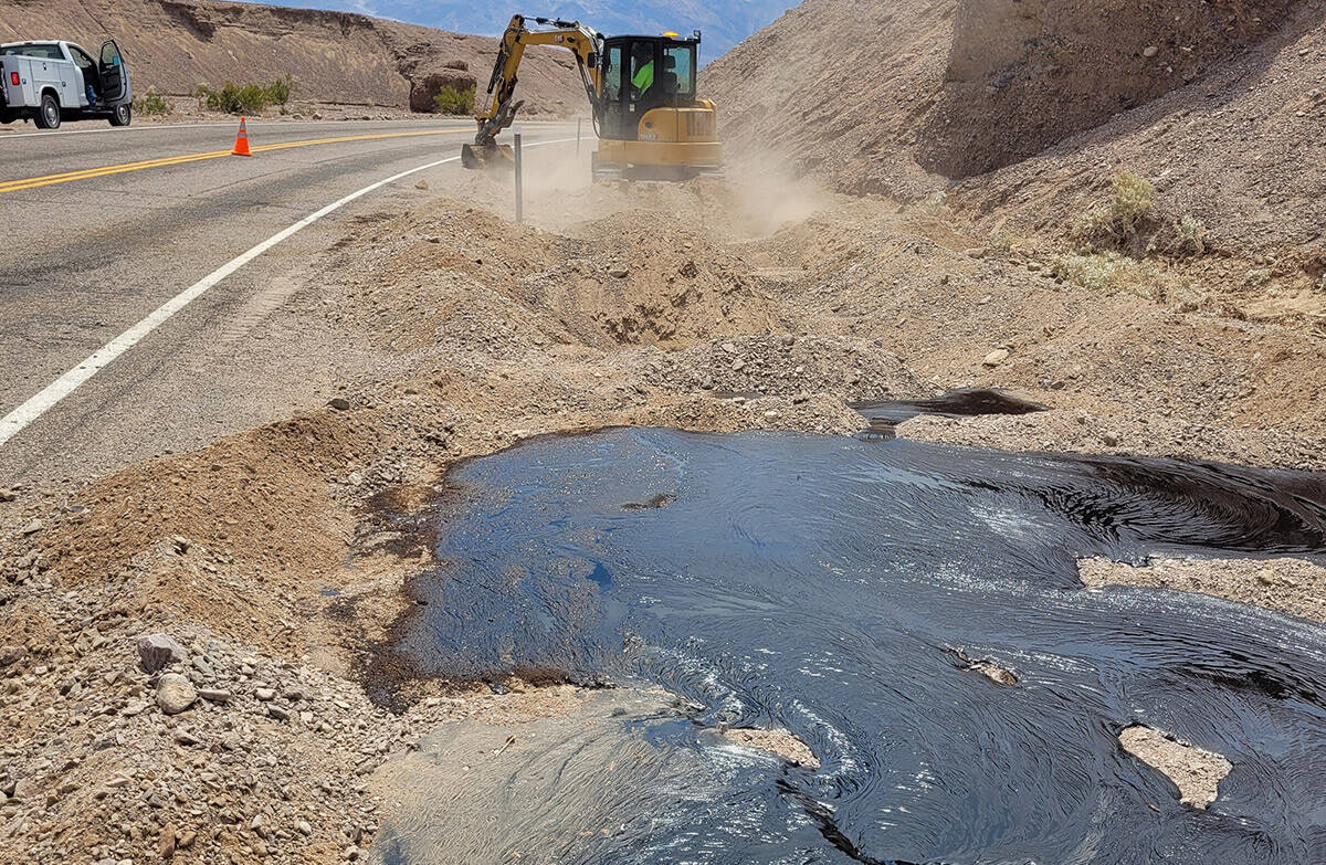 A NPS equipment operator digs a trench to contain the emulsified asphalt. (National Park Service)