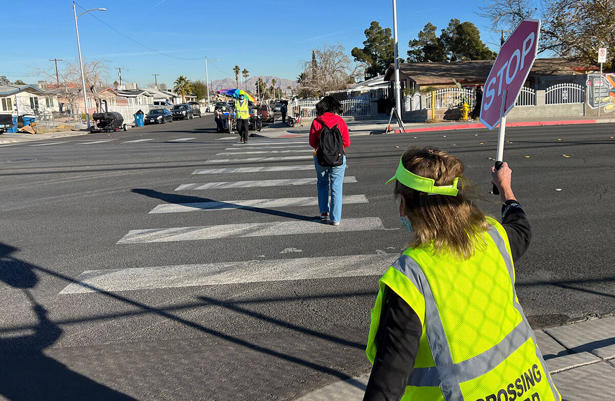 Crossing Guard Connie Walsh helps a student cross the street at Warren Elementary School in Las ...