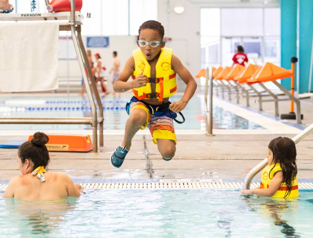 Ashton Taylor, 6, jumps into a pool at the City of Las Vegas Municipal Swimming Pool, on Monday ...