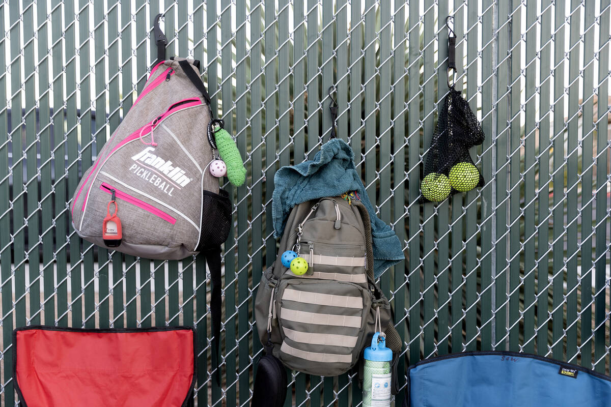 Pickleball bags, balls and accessories are hung on the court while members of the Neon Picklers ...