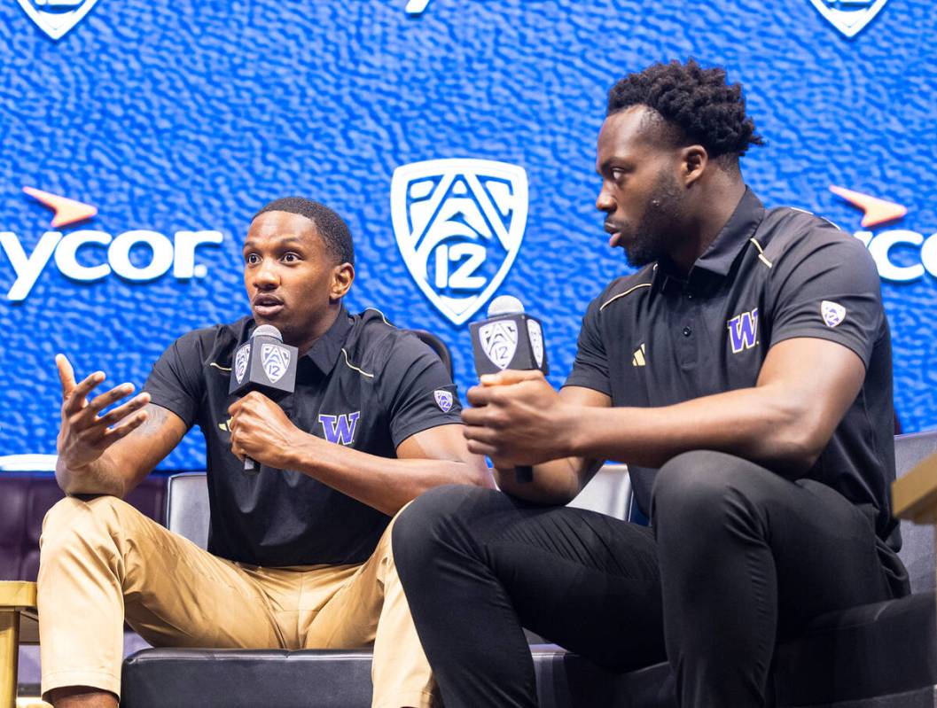 Washington Huskies quarterback Michael Penix Jr., left, speaks as linebacker Edefuan Ulofoshio ...