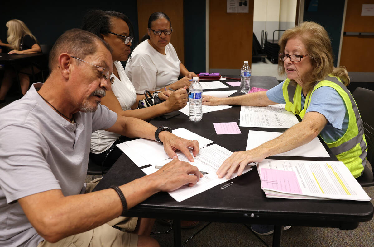 Pat Jaimes with All City Management Services, right, helps Servando Moreno during a school cros ...