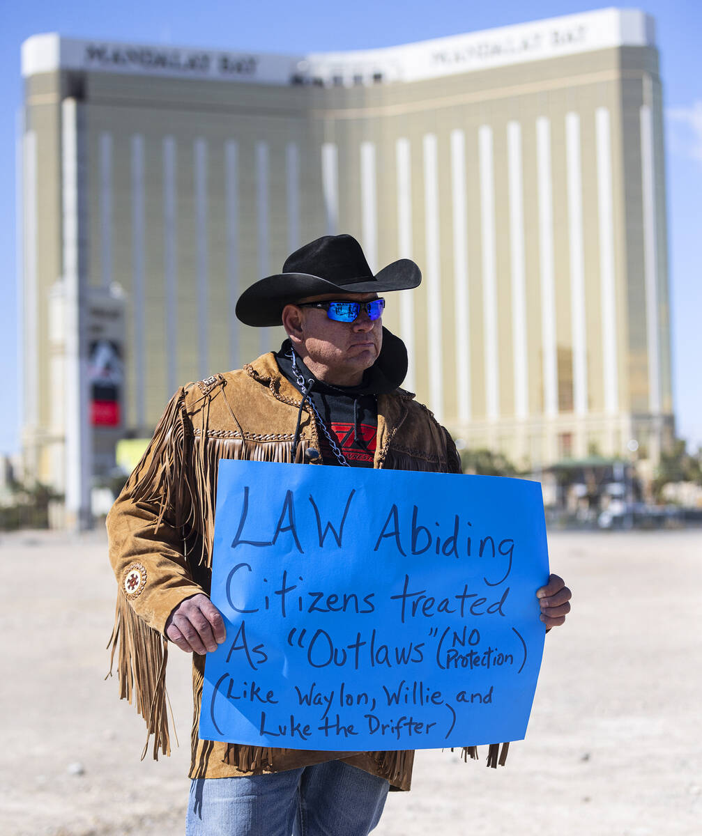 Todd Hall, a member of North Dakota's Mandan, Hidatsa and Arikara Nation (MHA), holds a sign as ...
