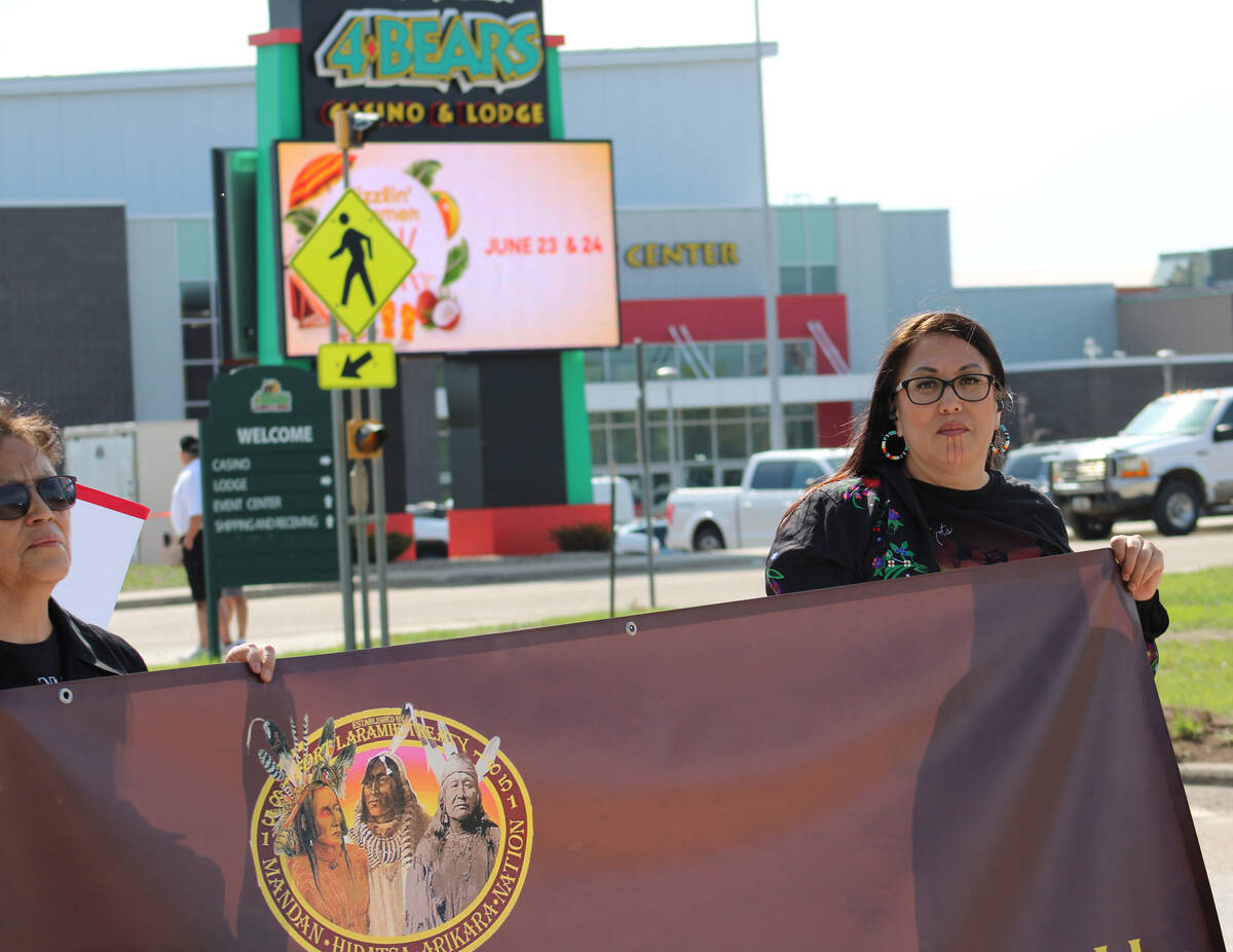 Kelly Hosie, right, holds a banner in protest of MHA Nation tribal leadership in New Town, Nort ...