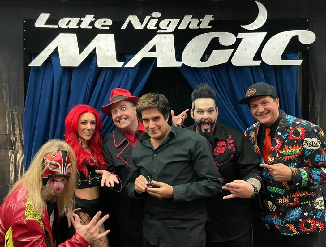 David Copperfield, holding his silver F-bomb counter, poses with the cast of "Late Night Magic" ...