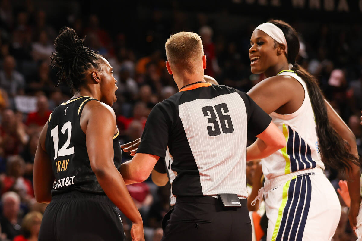 A referee breaks up a fight between Las Vegas Aces guard Chelsea Gray (12) and Dallas Wings cen ...