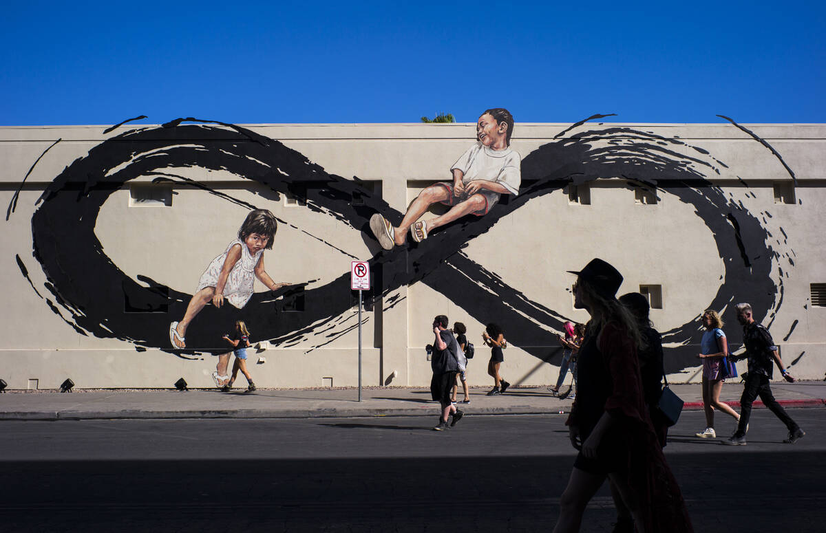 Attendees pass by a mural by Ernest Zacharevic during day 2 of the Life is Beautiful festival i ...