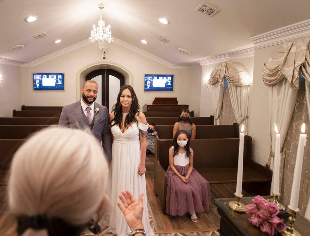 William and Brandi Alexander, from Anchorage, Alaska, listen to their officiant during a vow re ...