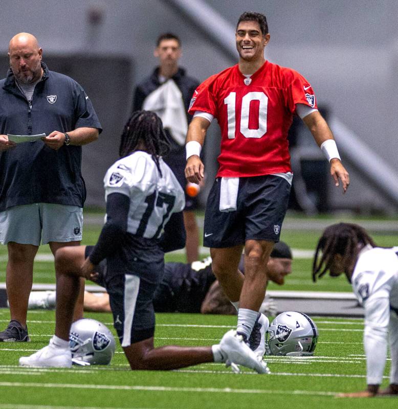 Raiders quarterback Jimmy Garoppolo (10) talks with wide receiver Davante Adams (17) during tra ...