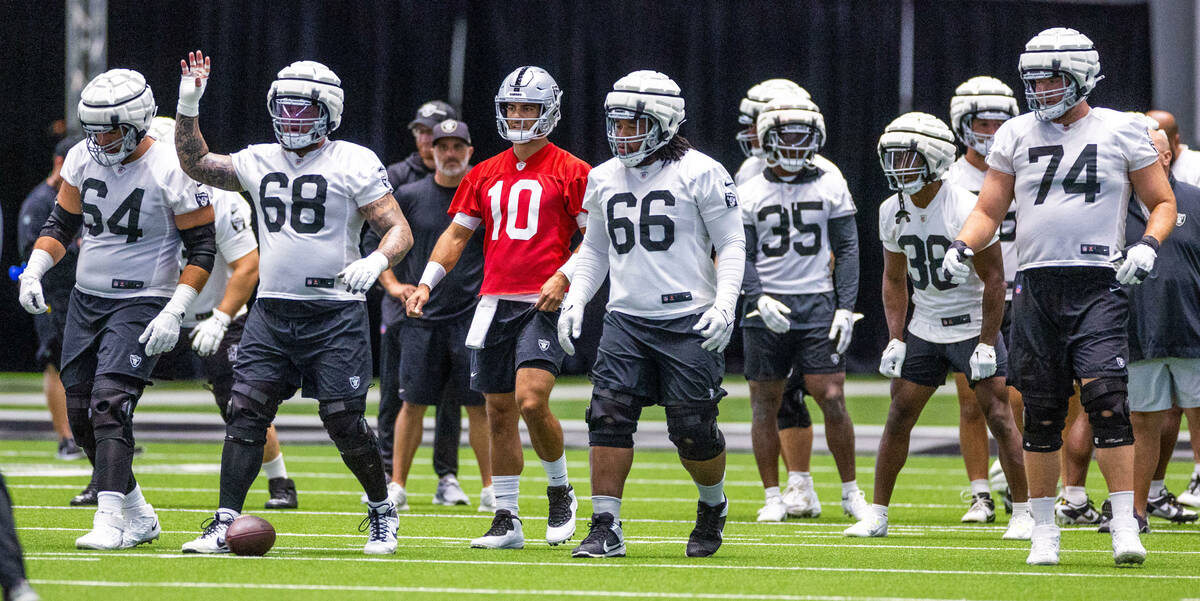 Raiders quarterback Jimmy Garoppolo (10) comes to the offensive line for another play with team ...