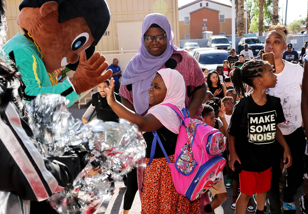 Third grader Fardousa Mabamed, 7, and her sister Hawa Mabamed walk the red carpet during the an ...