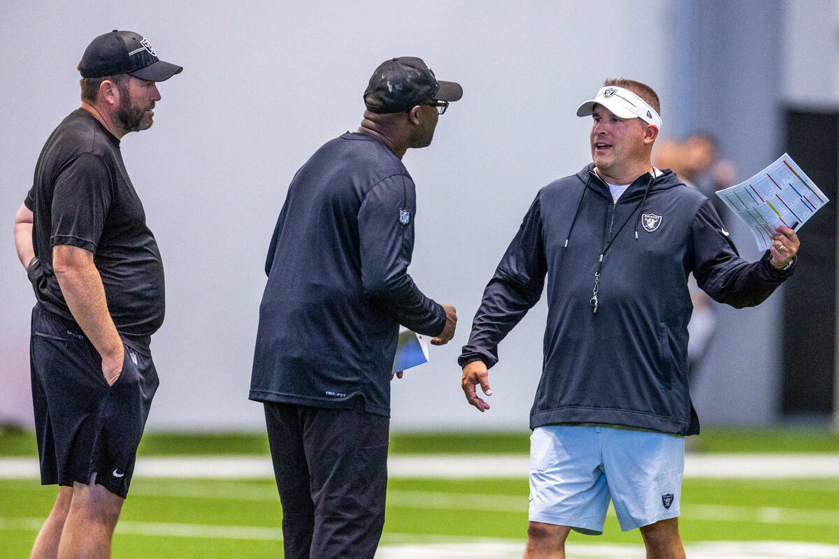 Raiders head coach Josh McDaniels talks with wide receivers coach Edgar Bennett and pass game c ...