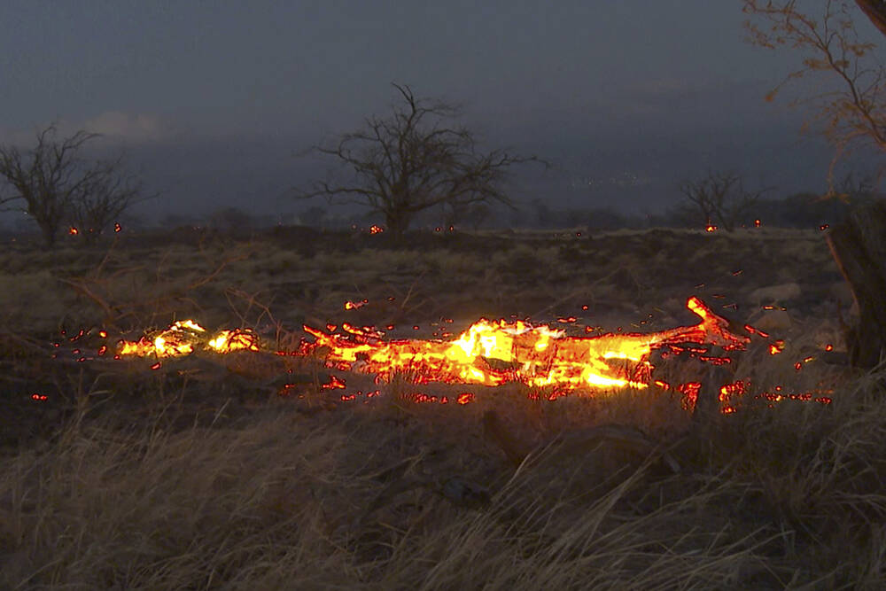 Flames from a wildfire burn in Kihei, Hawaii Wednesday, Aug. 9, 2023. Thousands of residents ra ...