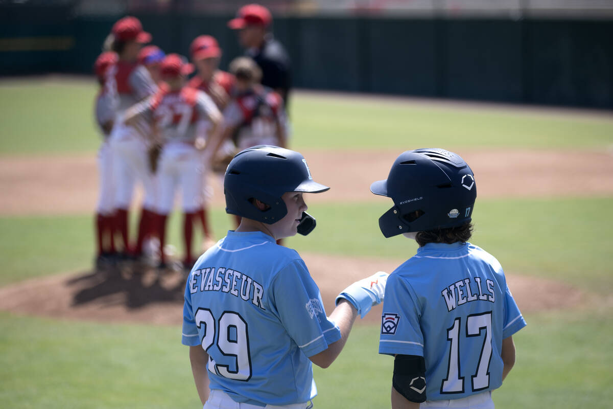 Henderson third baseman Logan Lavasseur (29) and extra hitter Liam Wells (17) communicate while ...