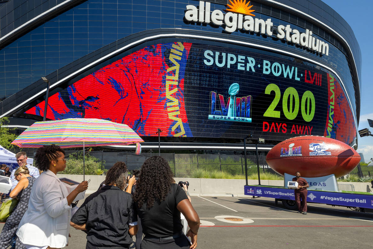 Jeremy Washington, right, of Mr. Jeremy's Grand Delights, has his photo taken by the Super Ball ...