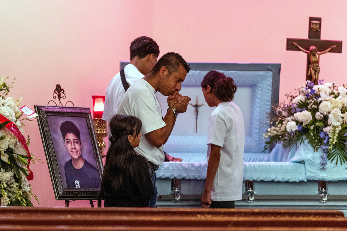 Rudolfo Naranjo prays beside family members at the casket of his son Angel before funeral servi ...