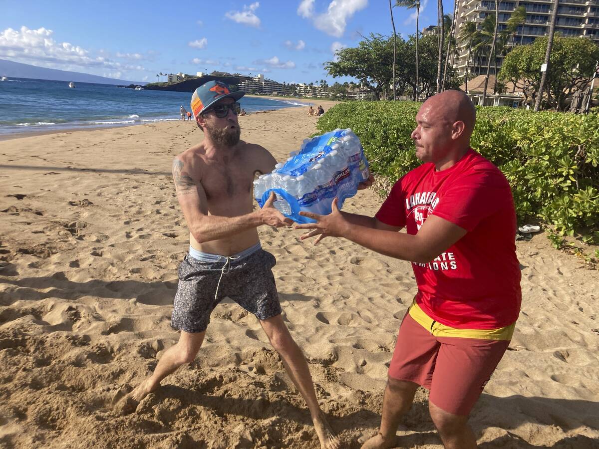 A group of volunteers who sailed from Maalaea Bay, Maui, form an assembly line on Kaanapali Bea ...