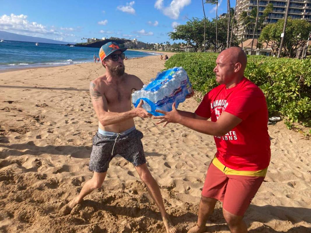 A group of volunteers who sailed from Maalaea Bay, Maui, form an assembly line on Kaanapali Bea ...