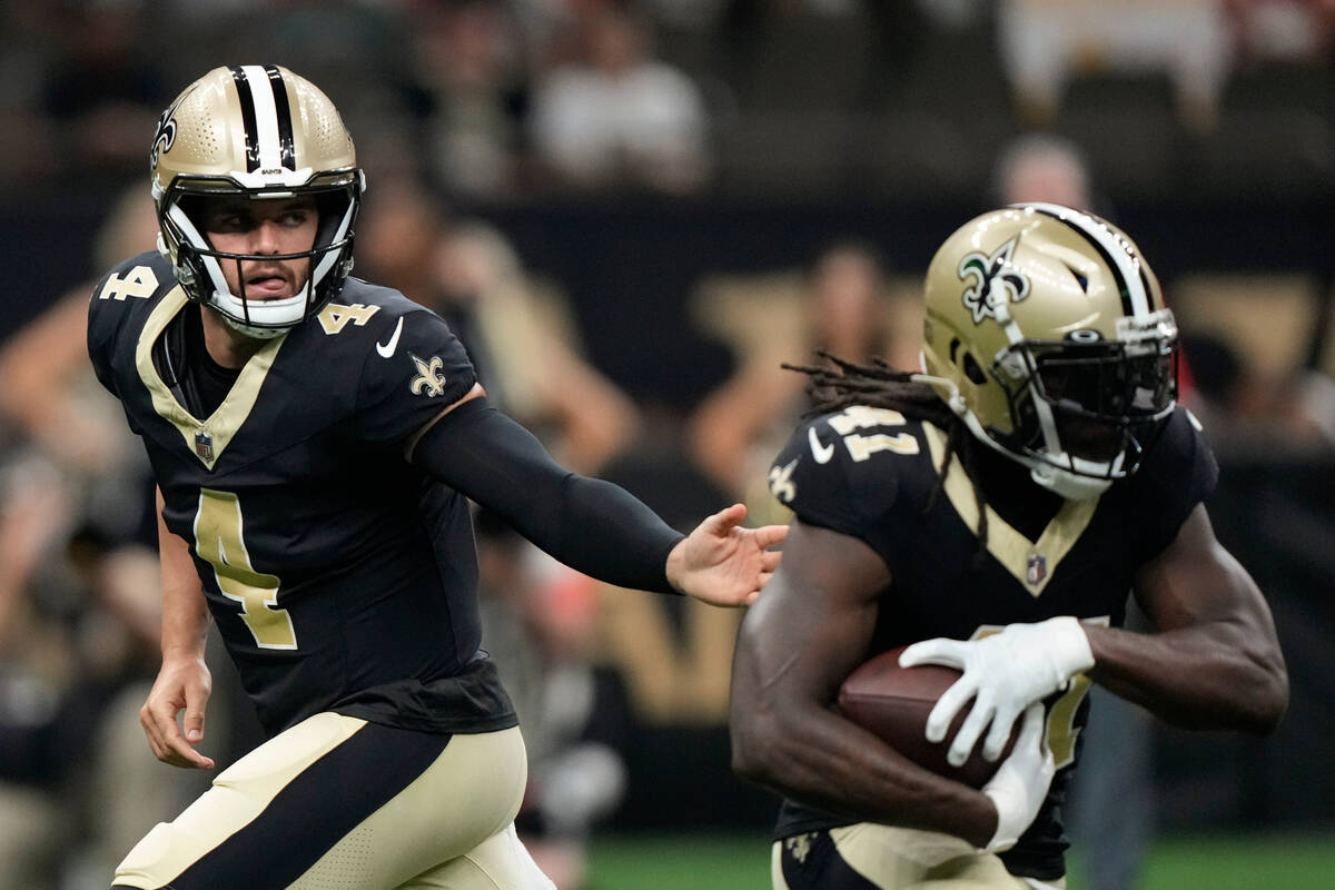 New Orleans Saints quarterback Derek Carr (4) hands the ball off to New Orleans Saints running ...