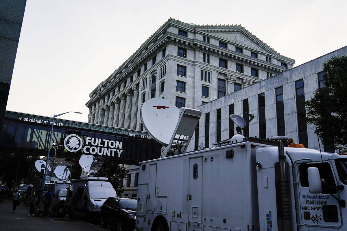 Media vehicles stage outside the Fulton County Courthouse, Monday, Aug. 14, 2023, in Atlanta. ...