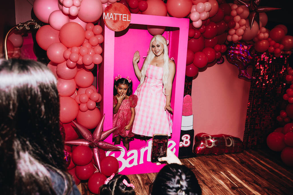Dibenhi Cadiz, 5, left, poses for a photo with Barbie inside of a life-size doll box at a Barbi ...
