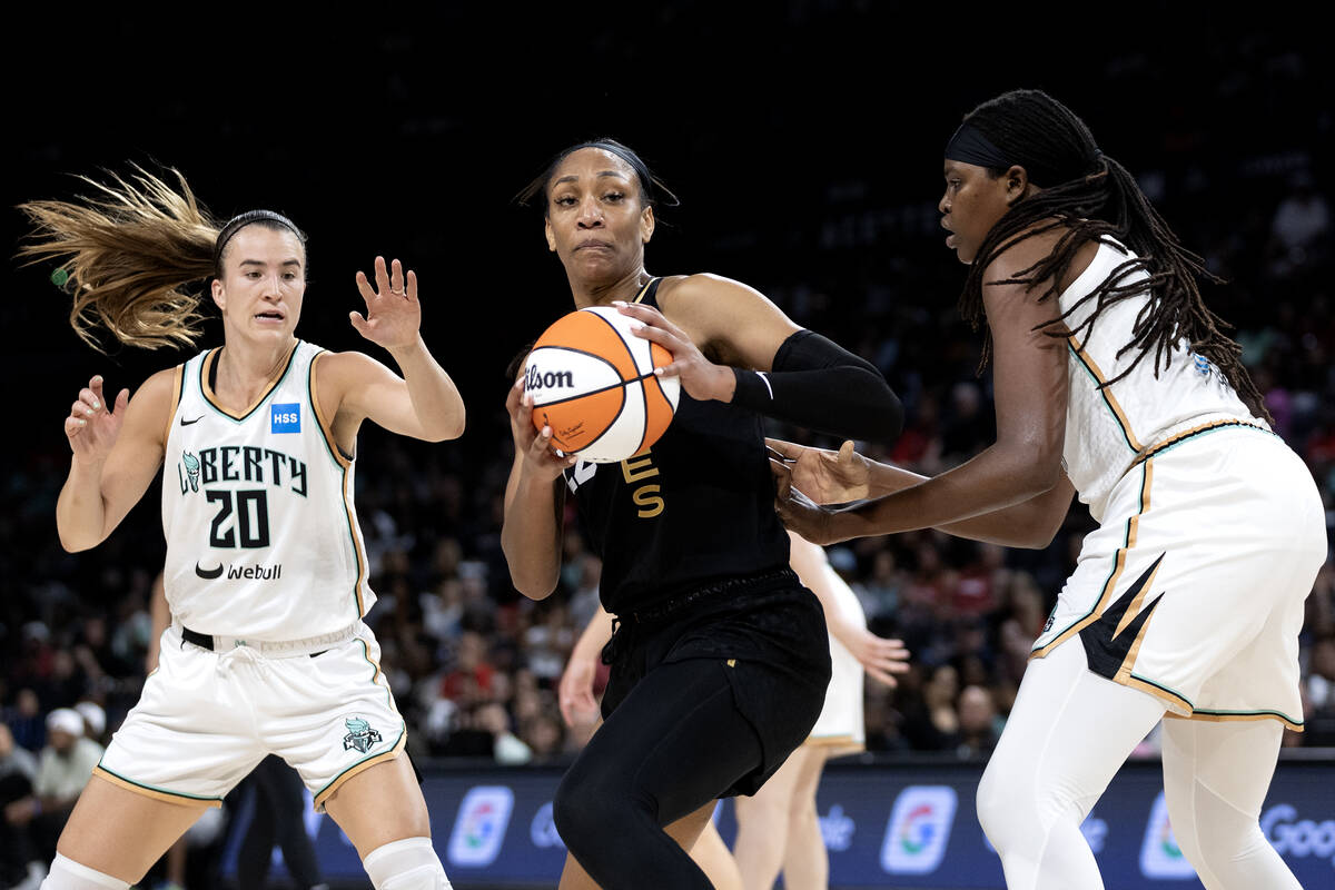 Las Vegas Aces forward A'ja Wilson (22) pivots to hoot between New York Liberty guard Sabrina I ...