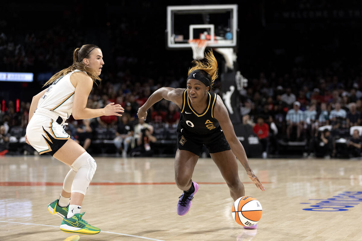 Las Vegas Aces guard Jackie Young (0) dribbles toward the hoop while New York Liberty guard Sab ...