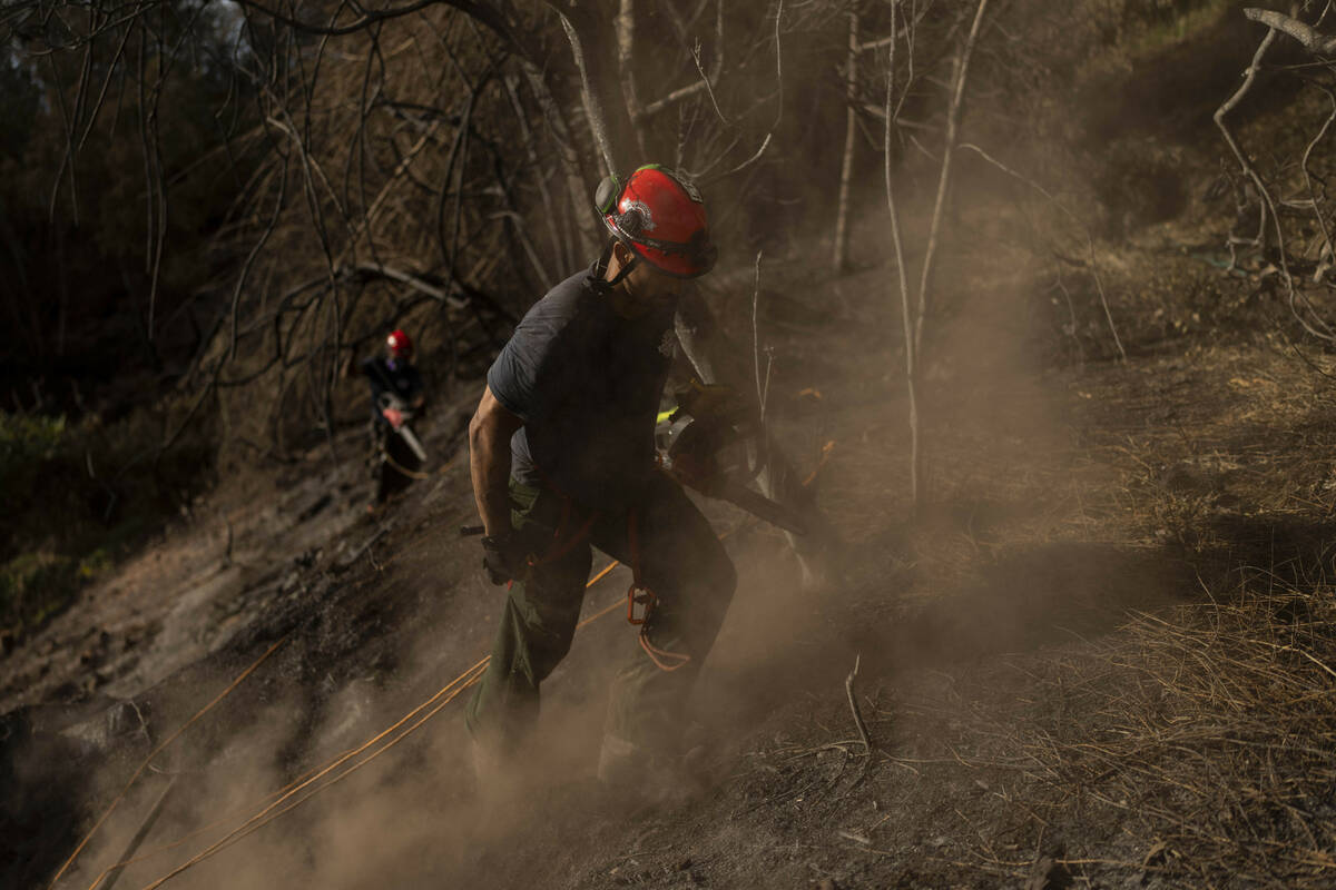 Firefighters clear debris in Kula, Hawaii, Tuesday, Aug. 15, 2023, following wildfires that dev ...