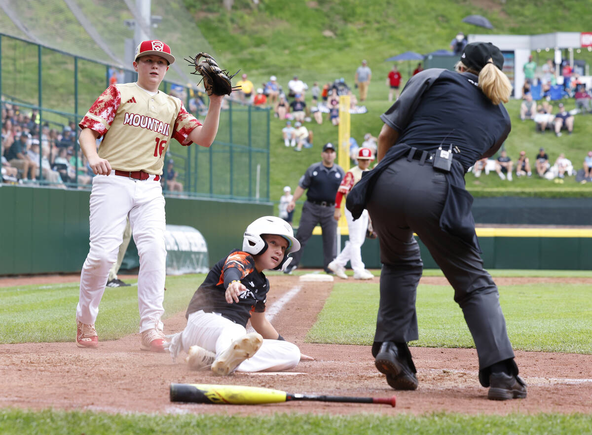 Rhode Island's John Wozniak is tagged out at home by the Henderson All-Stars pitcher Logan Leva ...